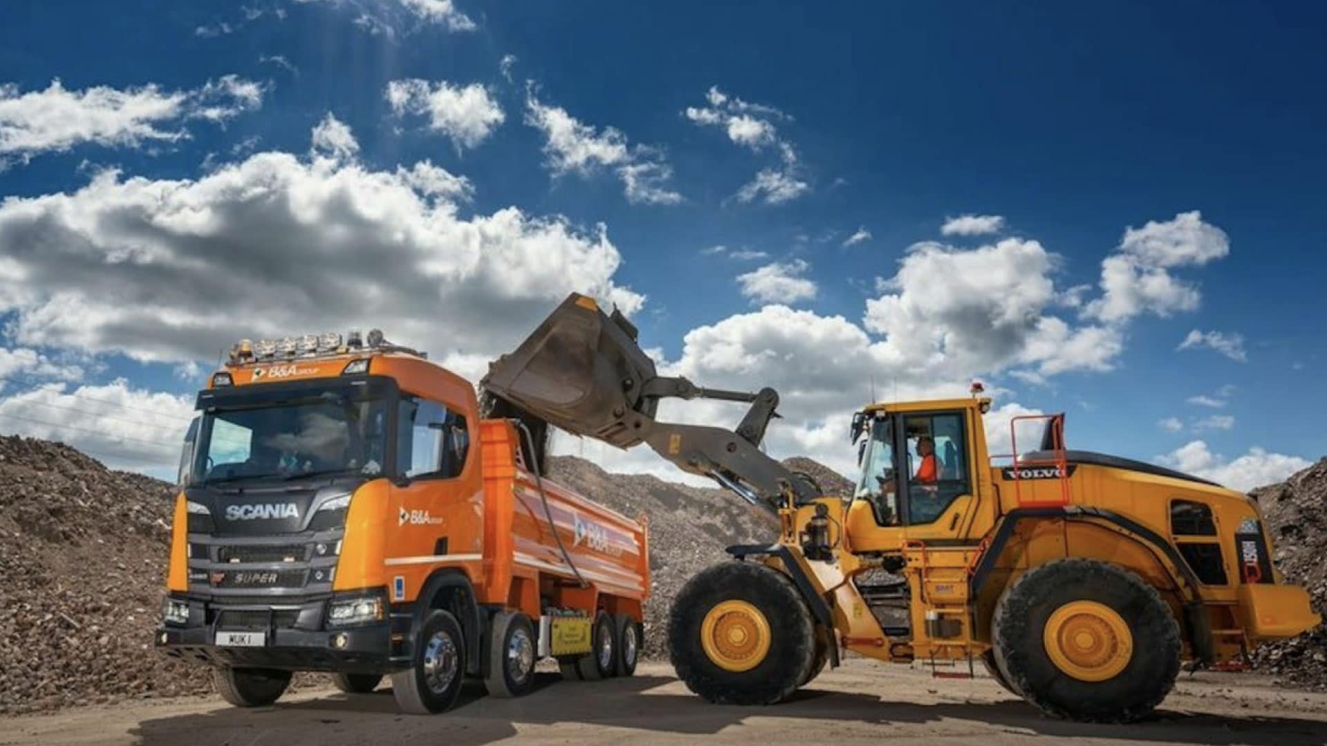 A bulldozer and a trailer truck working on a construction site, showcasing the importance of differentiating your aggregate business through efficient logistics and quality service.